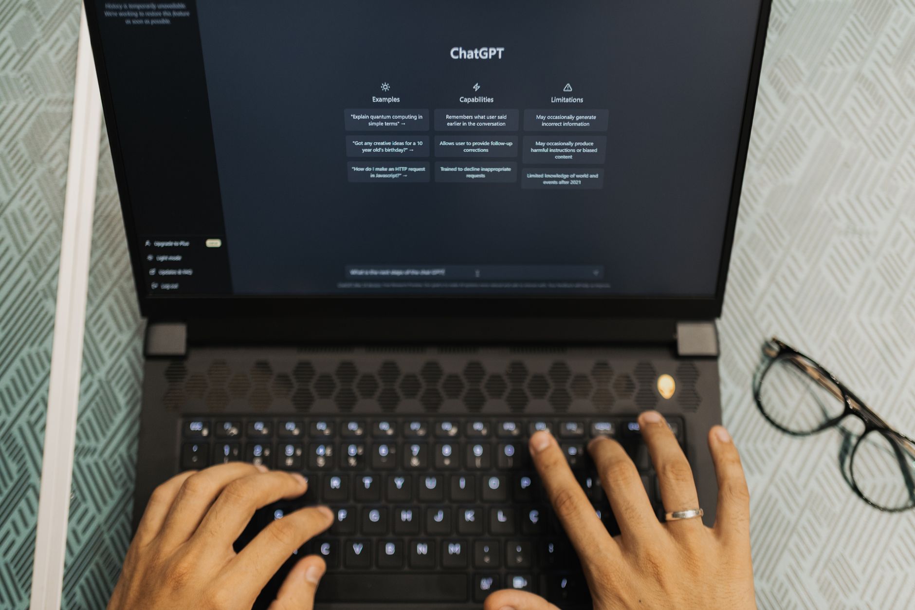 Hands typing on a laptop with the ChatGPT sign-in page open