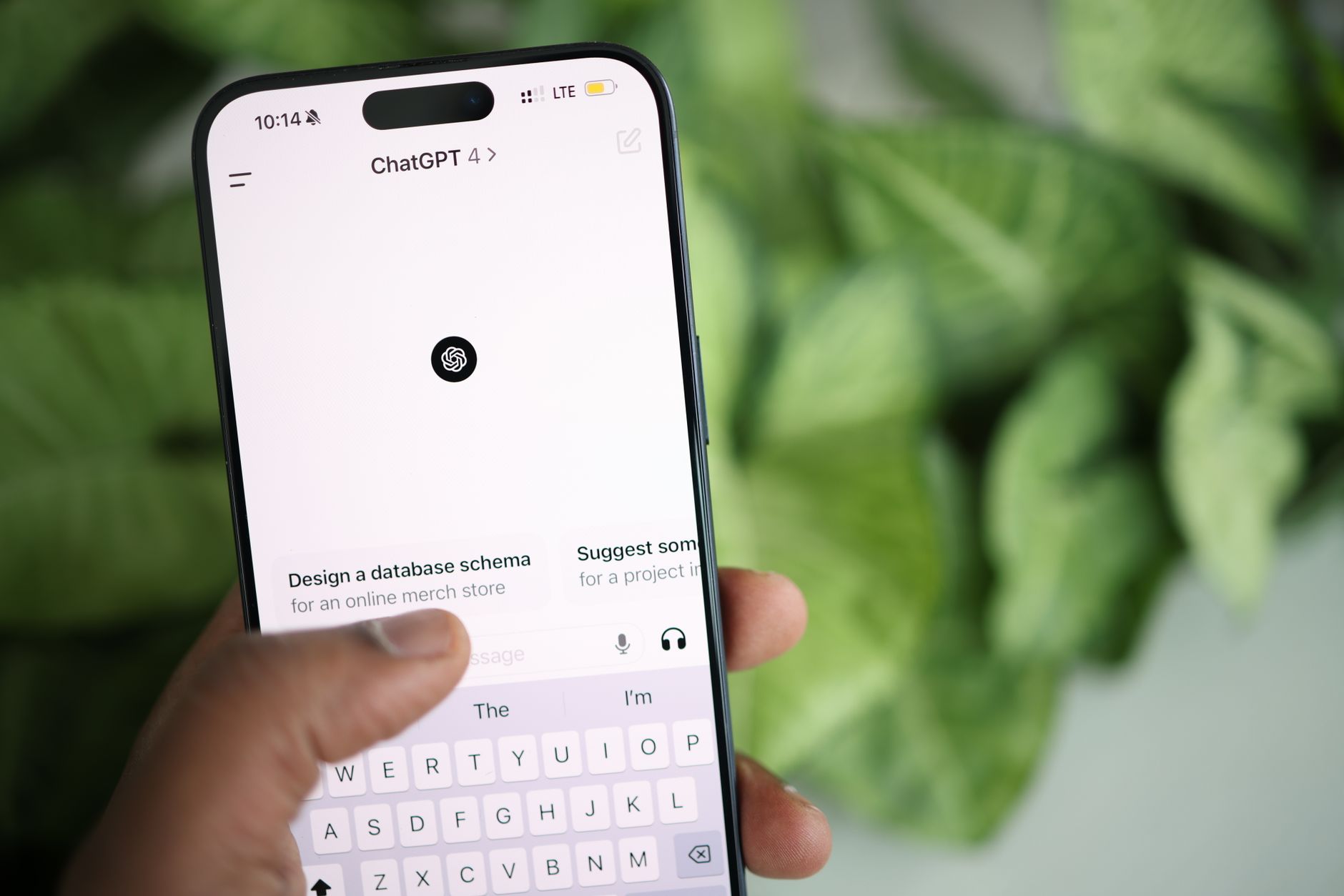 Hand holding a smartphone with the ChatGPT app open