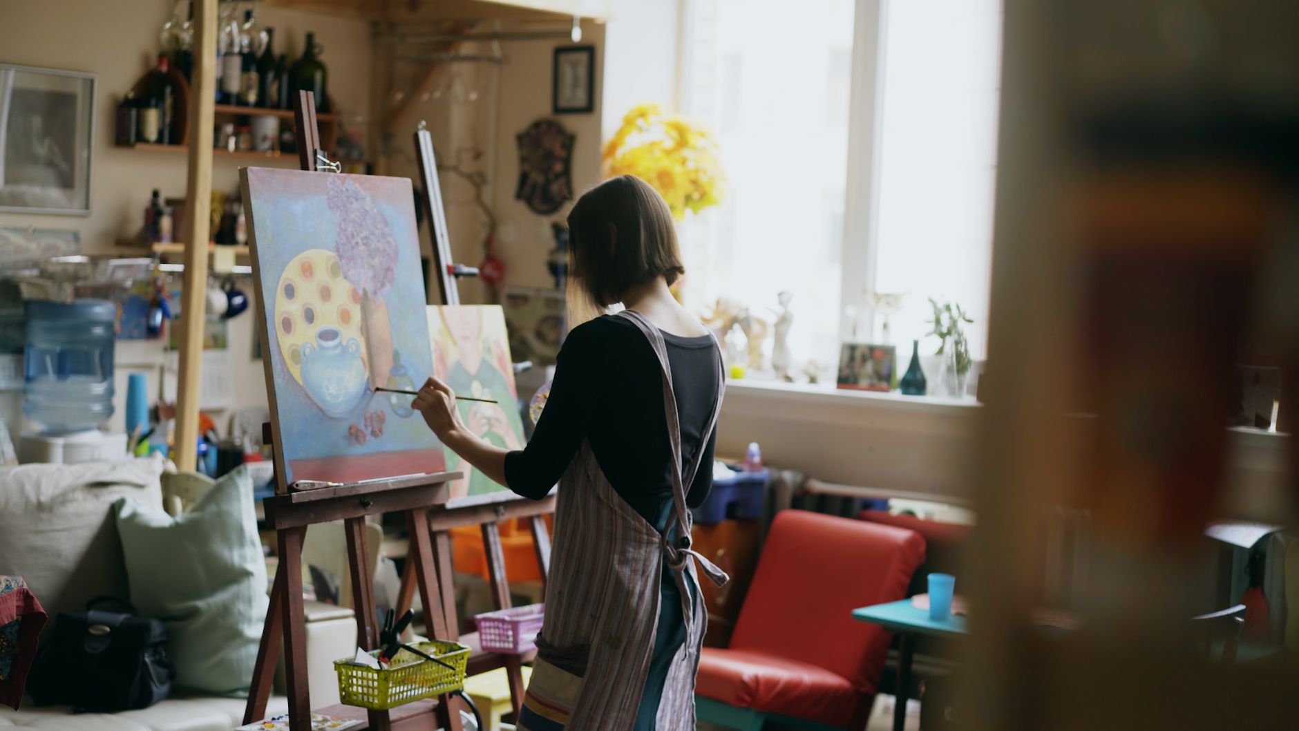 Woman painting in a sunlit home studio