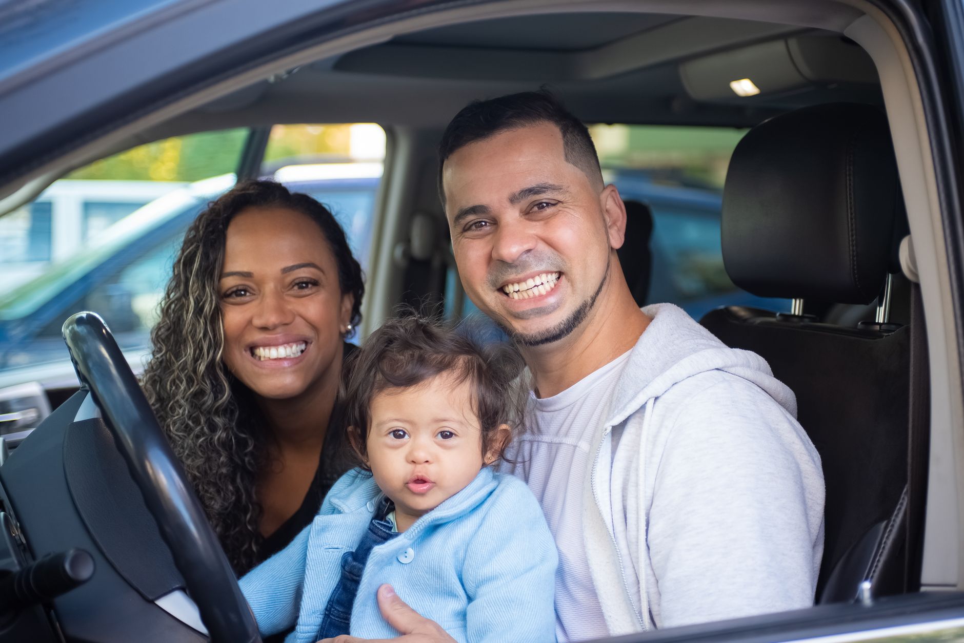 Smiling parents in the car with their child