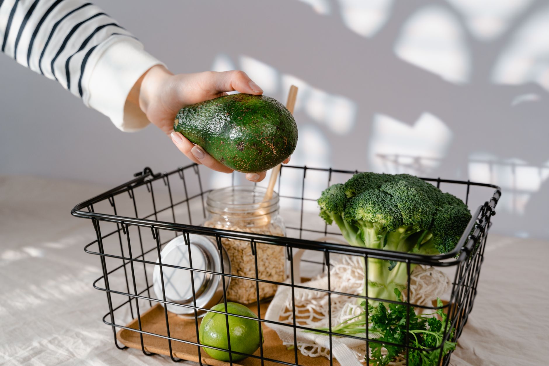 Grocery basket with avocado, broccoli and oats